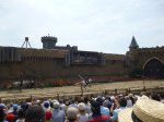 Horse riders hanging upside down as they fly past as part of the secret of the lance show at Puy du Fou