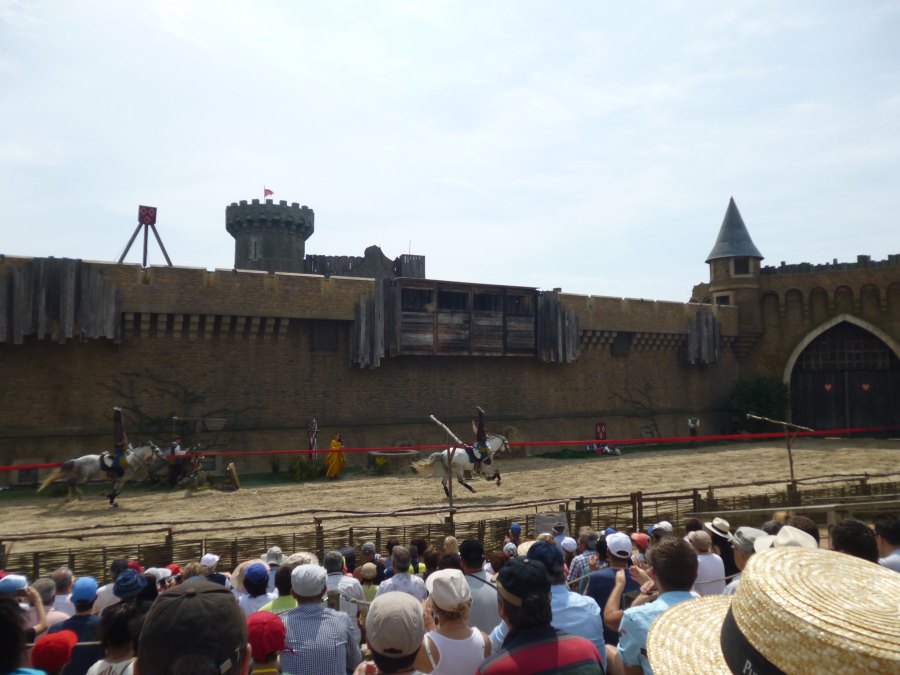 Horse riders hanging upside down as they fly past as part of the secret of the lance show at Puy du Fou